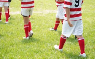 八代ラグビースクールの小学生ラガーマンたちが芝生の上を歩く様子